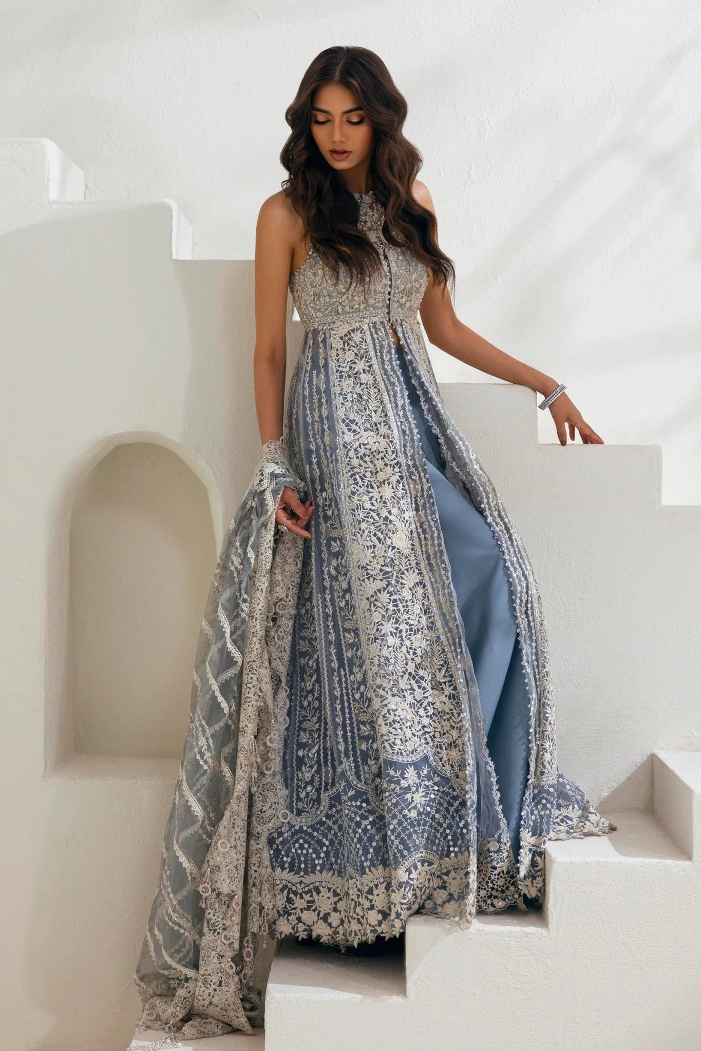 Model wearing N242 - 004 - 3CT dress from Sana Safinaz in a stunning blue color with intricate silver embroidery. Pakistani wedding clothes, available online in the UK.