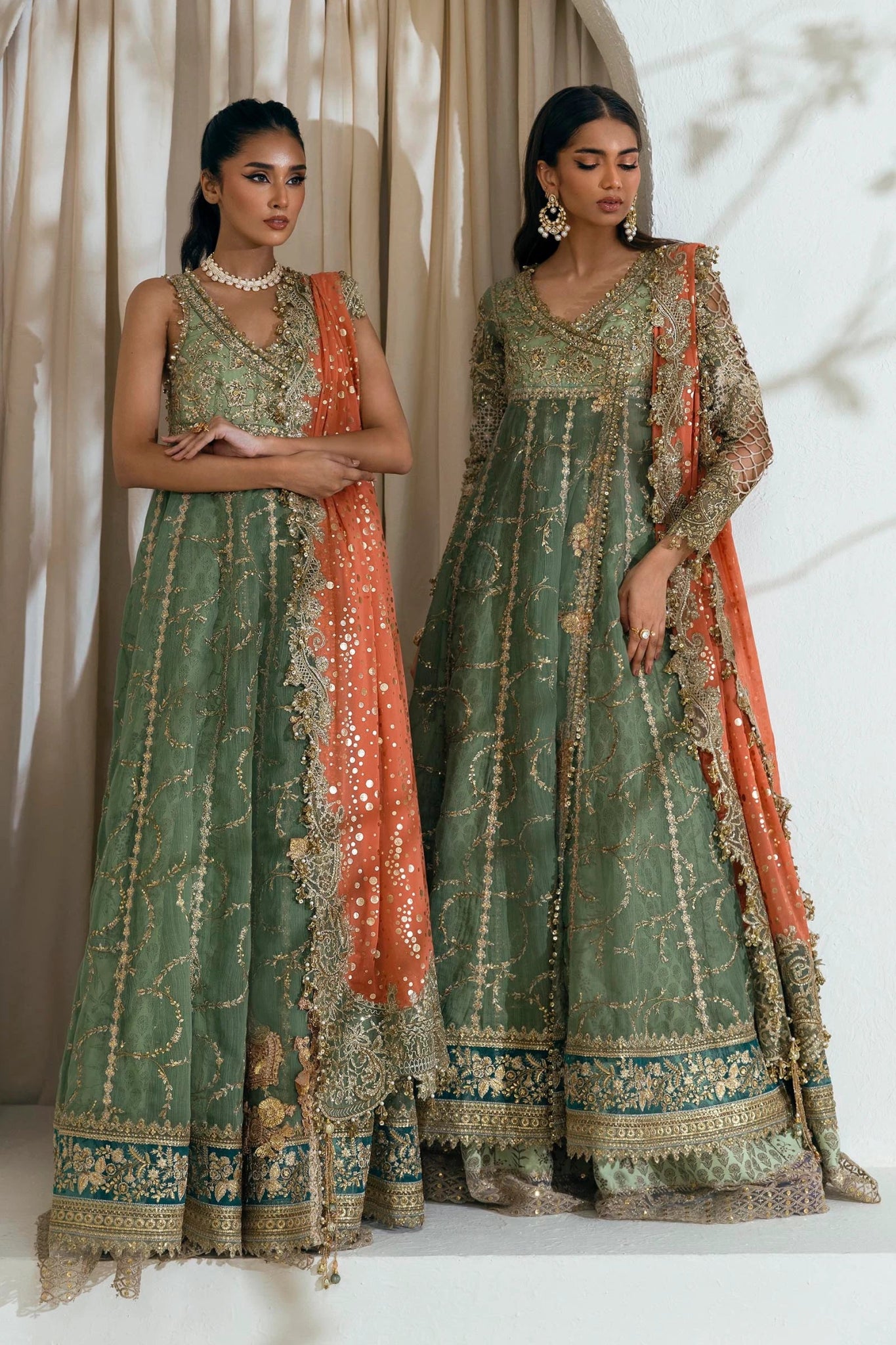 Model wearing Sana Safinaz NURA Festive'24 Vol. II N242 - 006 - 3CX dress, featuring a green ensemble with gold embellishments and an orange dupatta. Perfect for weddings and available as Pakistani clothes online in the UK.