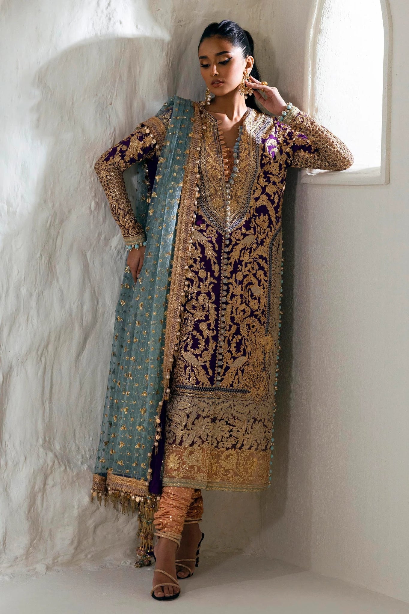 Model wearing a Sana Safinaz NURA Festive'24 Vol. II N242 - 007 - 3CX purple and gold embroidered dress with a blue dupatta. Perfect for Pakistani clothes online in UK, wedding clothes.