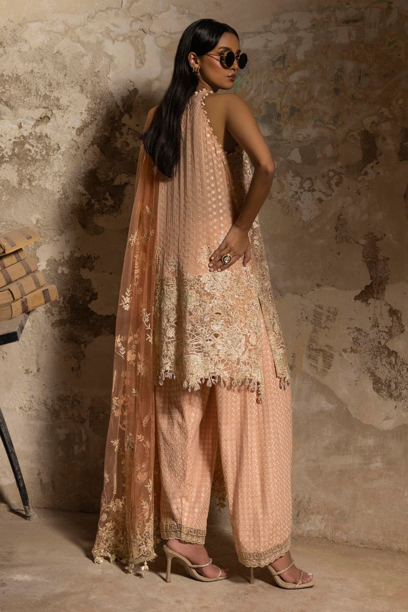 Model in a luxurious Sana Safinaz Nura Vol. 3 2024 peach outfit with hand - embellished georgette, embroidered net dupatta, and raw silk trousers, perfect for formal events. Available online in the UK.