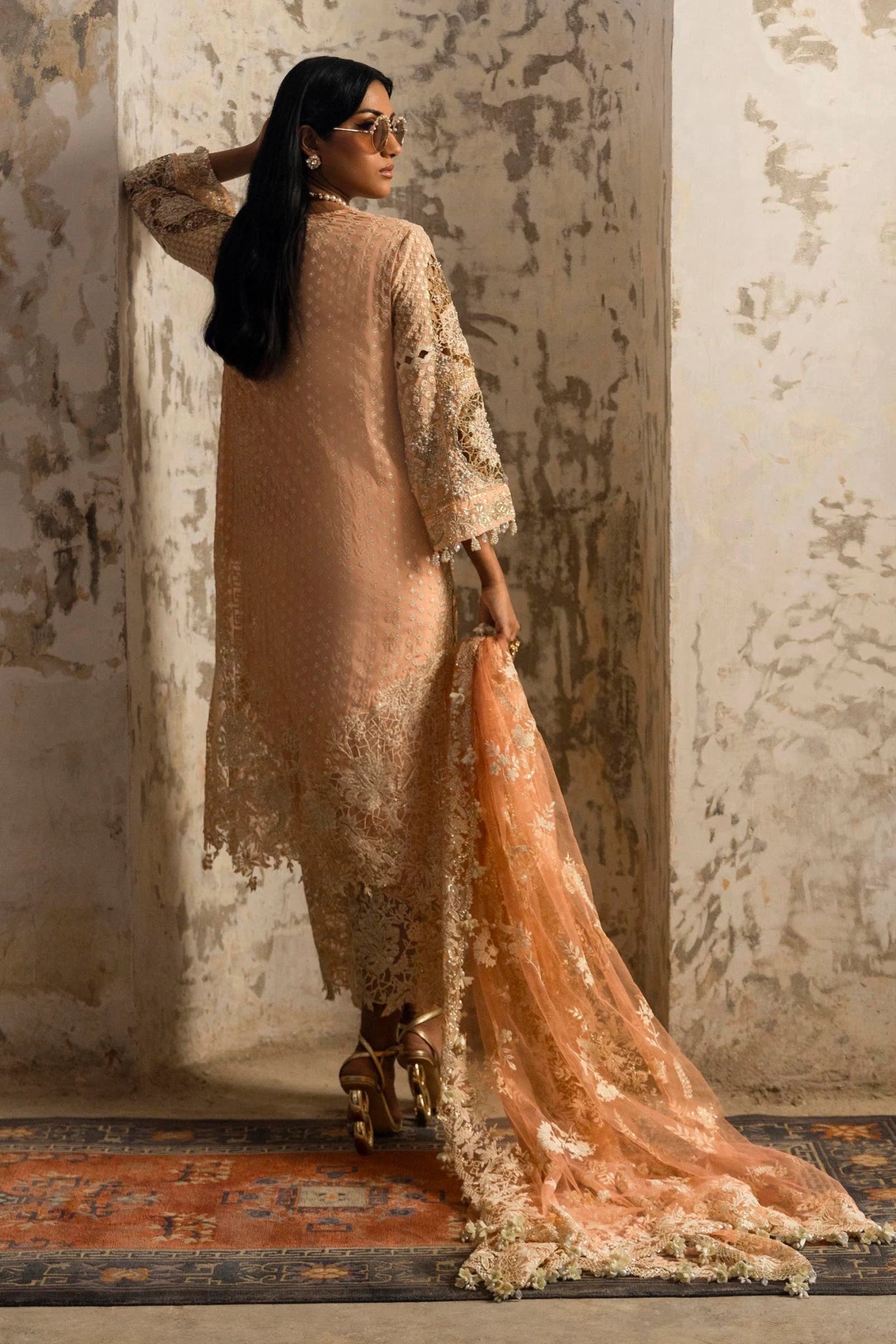 Model in a luxurious Sana Safinaz Nura Vol. 3 2024 peach outfit with hand - embellished georgette, embroidered net dupatta, and raw silk trousers, perfect for formal events. Available online in the UK.