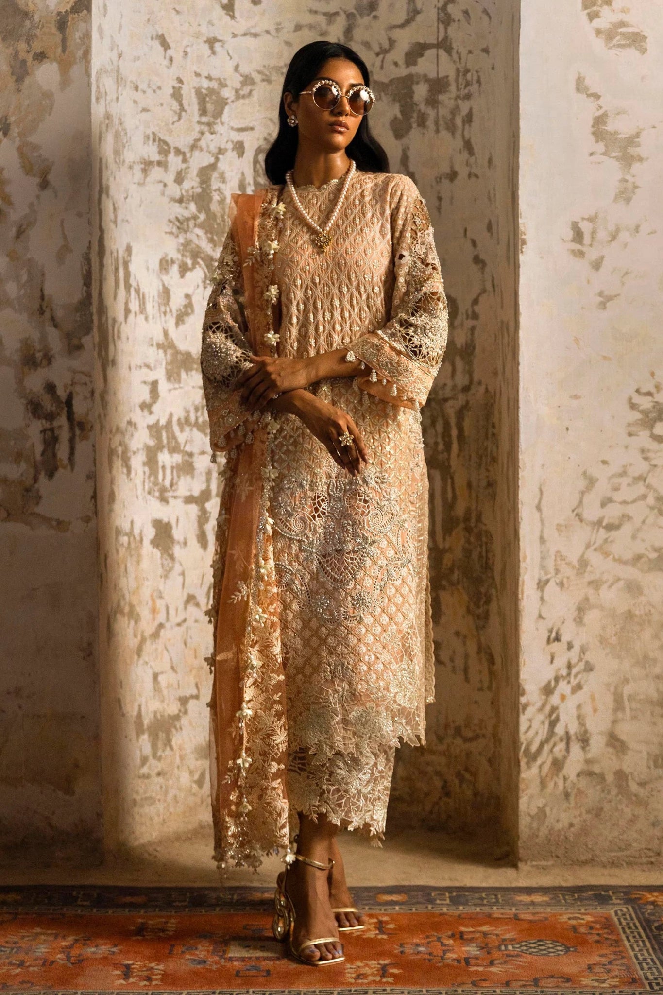 Model in a luxurious Sana Safinaz Nura Vol. 3 2024 peach outfit with hand - embellished georgette, embroidered net dupatta, and raw silk trousers, perfect for formal events. Available online in the UK.