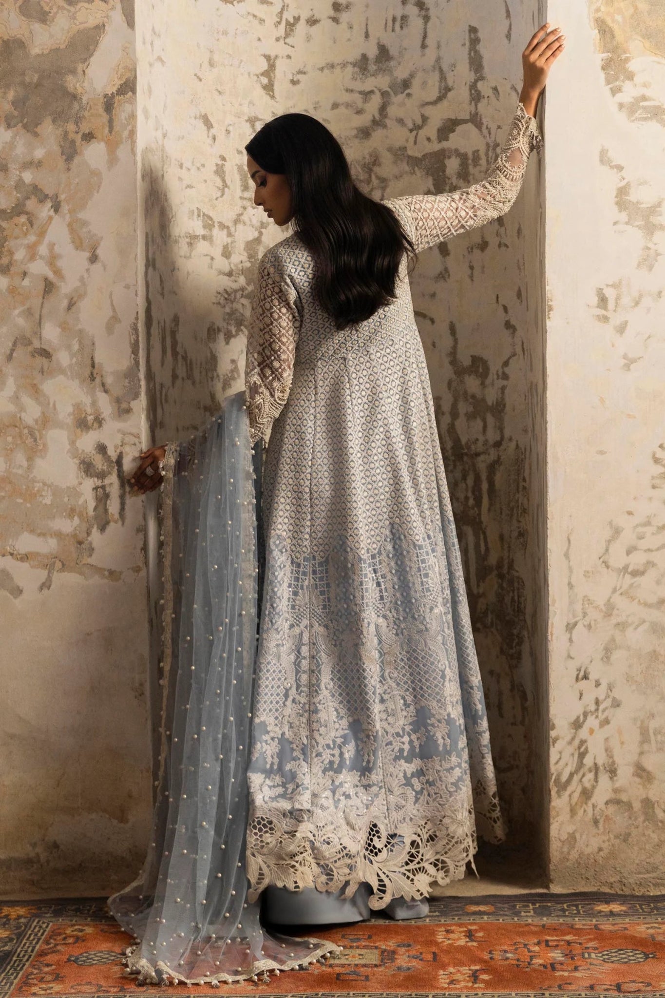 Model in a stunning Sana Safinaz Nura Vol. 3 2024 ice blue outfit featuring hand - embellished net, embroidered dupatta, and raw silk trousers. Ideal for formal events, available online in the UK.