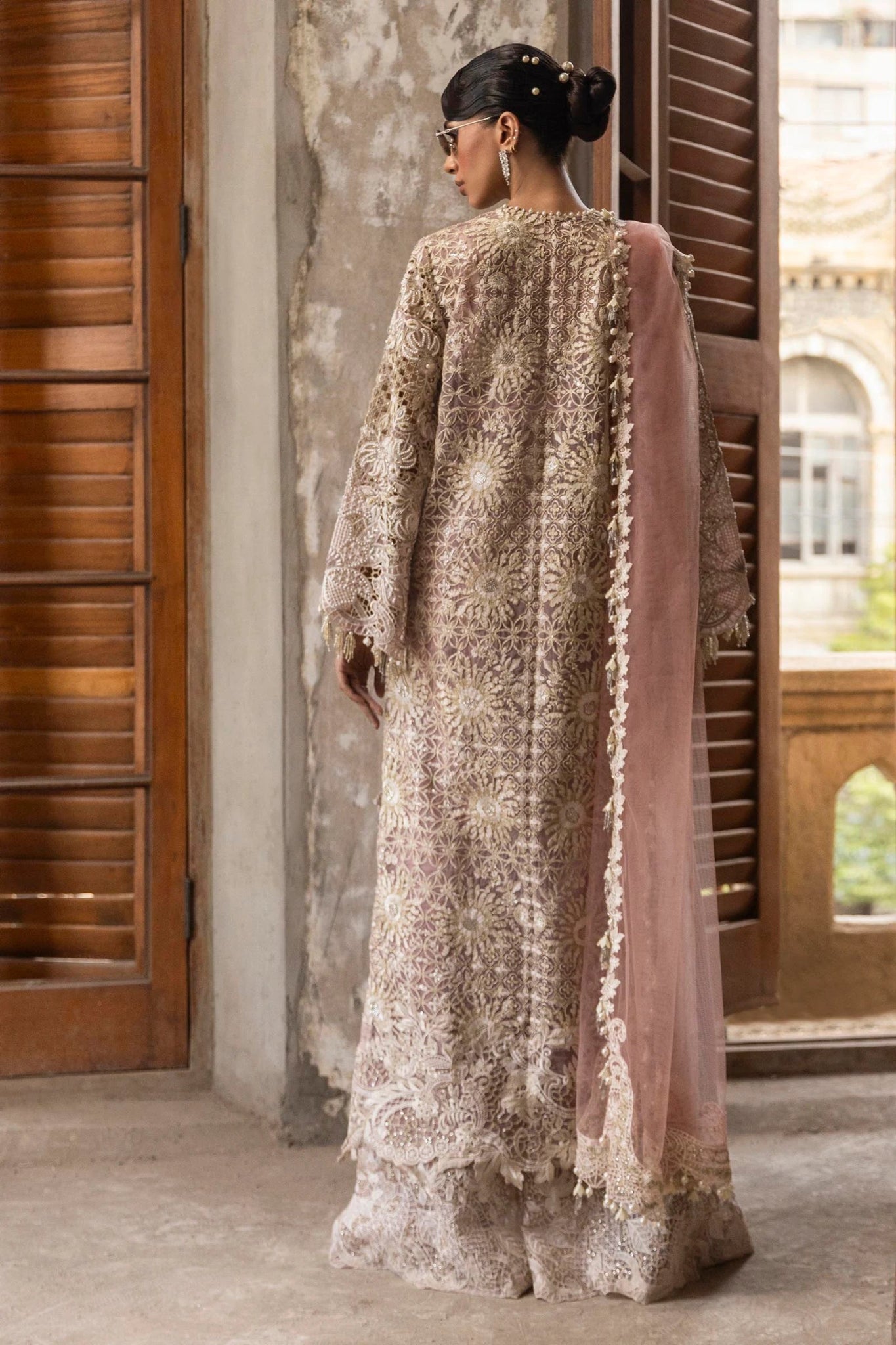 A stunning model poses in a luxurious hand - embellished lilac outfit from the Sana Safinaz Nura Vol.3 2024 collection, showcasing Pakistani fashion with intricate embroidery and luxury pret details. Available online in the UK.