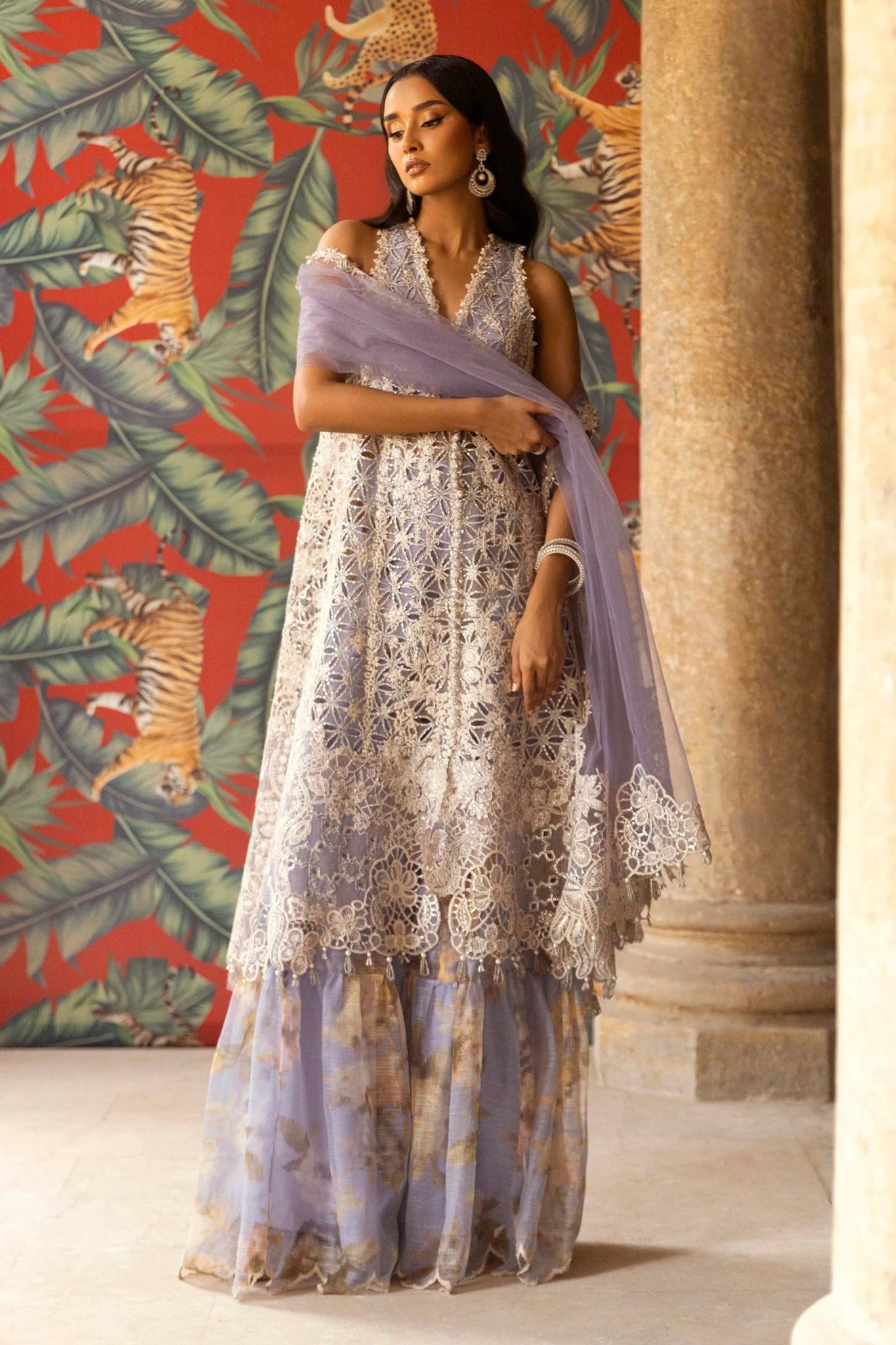 A stunning model showcasing a Sana Safinaz Nura Vol. 3 2024 lavender outfit with hand - embellished cutwork on organza, embroidered dupatta, and a digitally printed woven net lehenga. Perfect for formal occasions, this Pakistani luxury pret wear is available online in the UK exclusively at Signature Labels.