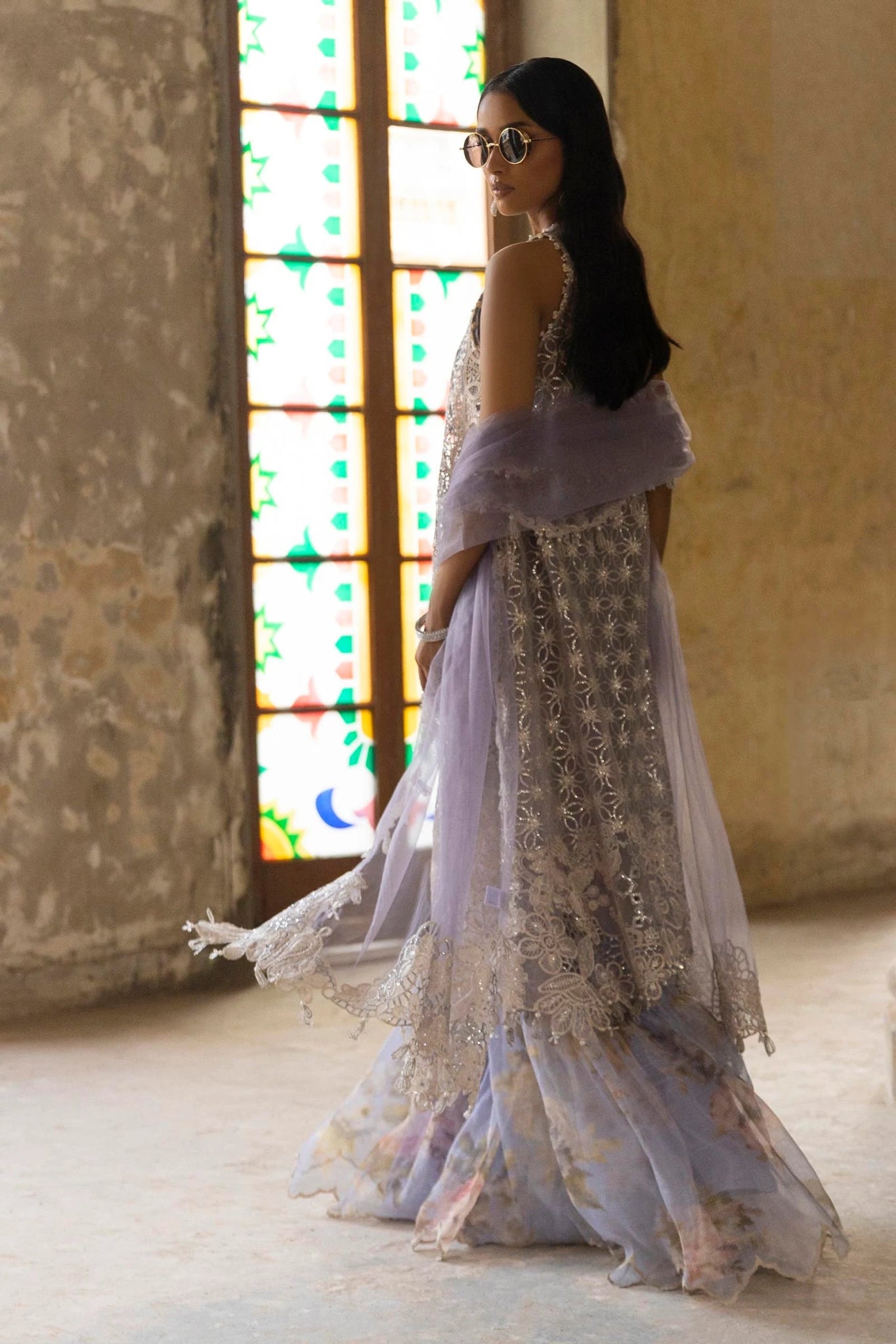 A stunning model showcasing a Sana Safinaz Nura Vol. 3 2024 lavender outfit with hand - embellished cutwork on organza, embroidered dupatta, and a digitally printed woven net lehenga. Perfect for formal occasions, this Pakistani luxury pret wear is available online in the UK exclusively at Signature Labels.