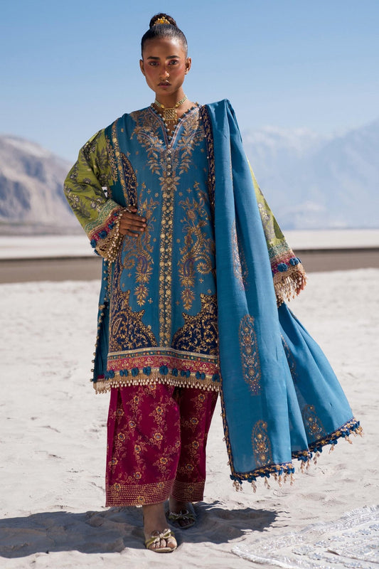 Model wearing Sana Safinaz Winter Luxury '24 S241 - 002B - 3CP, a vibrant blue and green embroidered ensemble with intricate gold details, ideal for winter. Perfect for Pakistani clothes online in the UK.