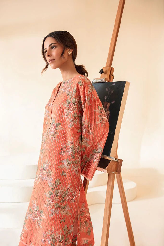 Model wearing Sobia Nazir Fall Edit '24 SNPP - 0325, featuring an orange outfit with intricate sleeve embroidery, perfect for winter casual pret. Available online in the UK.