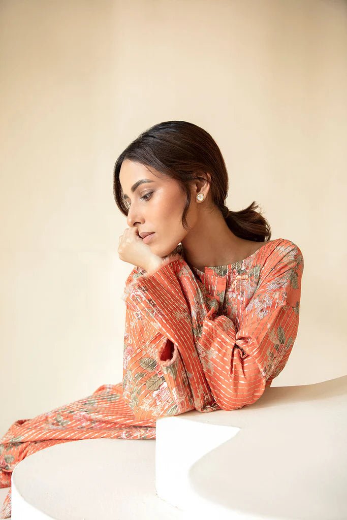 Model wearing Sobia Nazir Fall Edit '24 SNPP - 0325, featuring an orange outfit with intricate sleeve embroidery, perfect for winter casual pret. Available online in the UK.