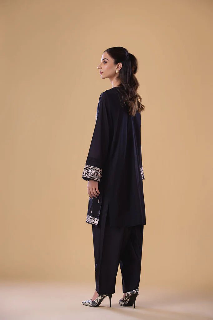 Model wearing a black SNEP - 24 - 0379 dress from Sobia Nazir's Pret '24 collection. Perfect for Pakistani clothes online in the UK.