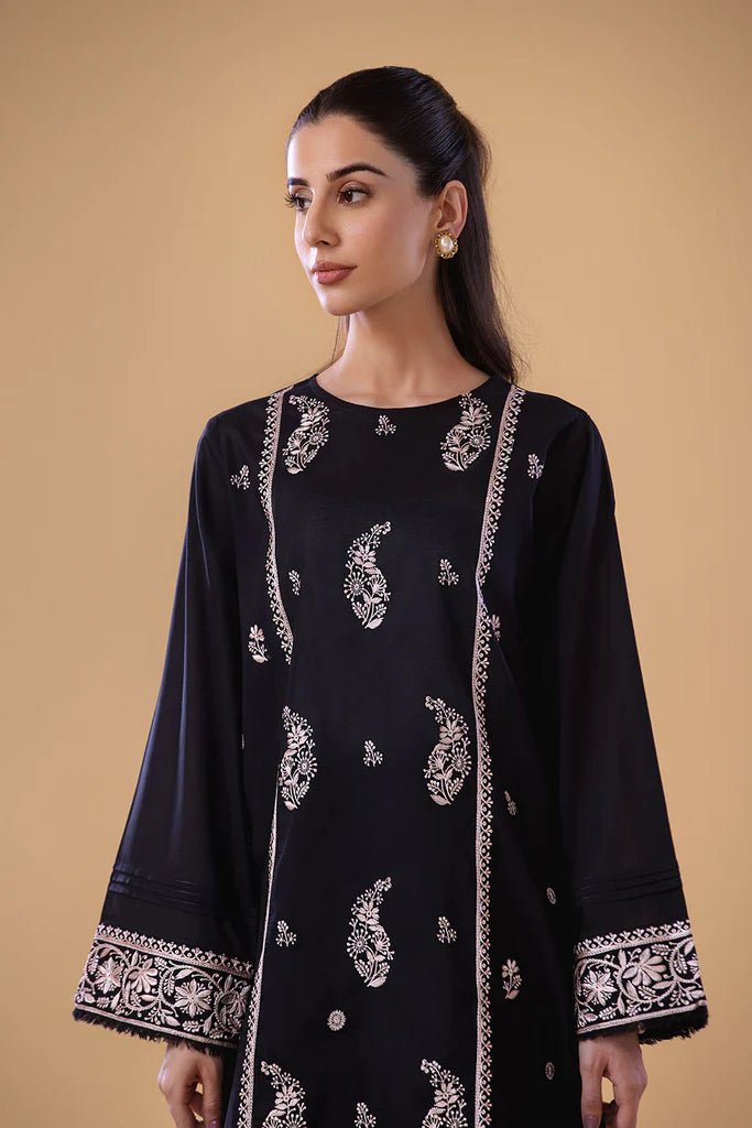 Model wearing a black SNEP - 24 - 0379 dress from Sobia Nazir's Pret '24 collection. Perfect for Pakistani clothes online in the UK.