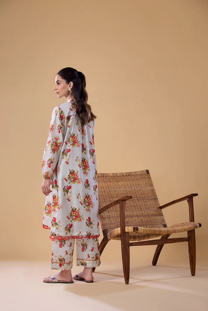 Model wearing a white dress with red and green floral print from Sobia Nazir's Pret '24 collection, SNPP - 24 - 0307. Perfect for showcasing Pakistani clothes online in the UK.