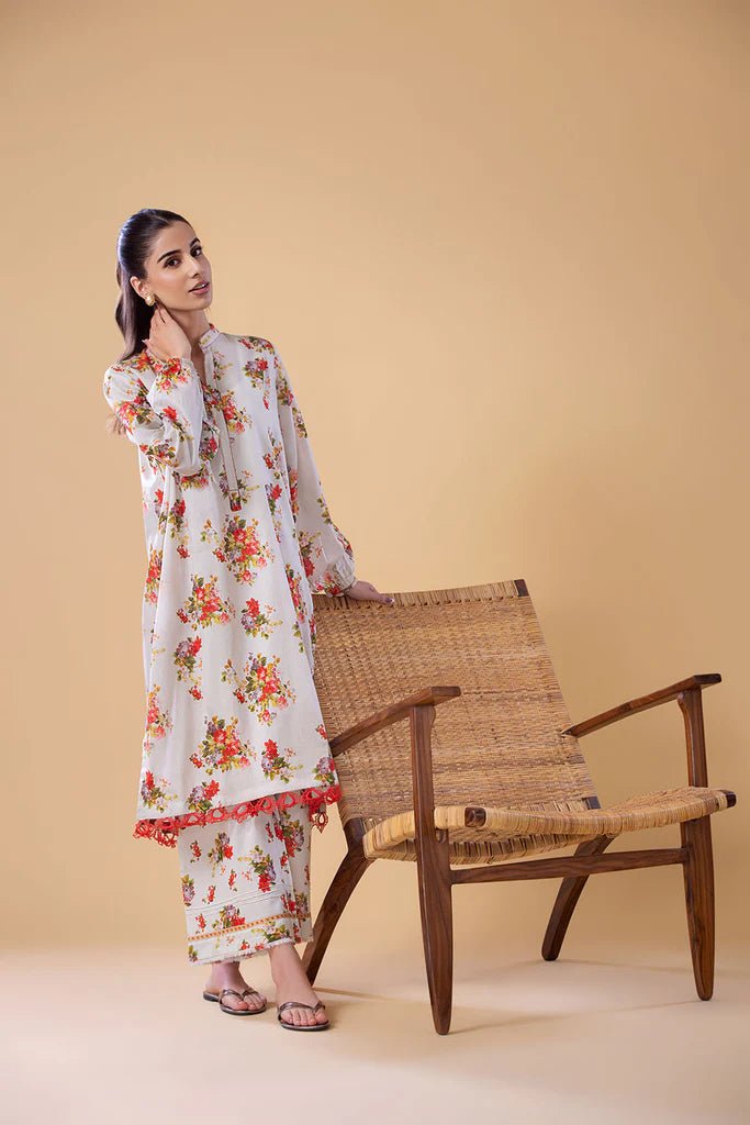 Model wearing a white dress with red and green floral print from Sobia Nazir's Pret '24 collection, SNPP - 24 - 0307. Perfect for showcasing Pakistani clothes online in the UK.