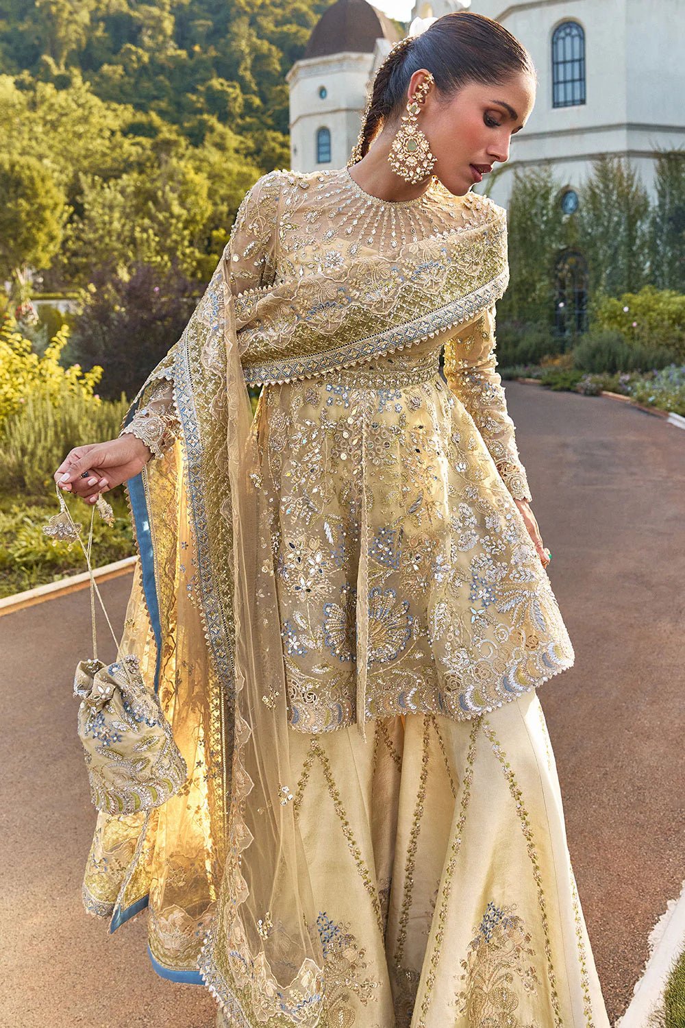 Model wearing Soraya Lumene Festive '25 Ornella dress in gold with intricate embellishments and embroidery. Shop Pakistani bridal dresses online in the UK now.