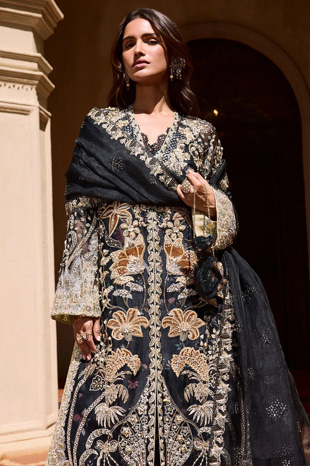 Model wearing Soraya Lumene Festive '25 Stella dress in black with intricate gold and silver embroidery. Shop Pakistani bridal dresses online in the UK now.