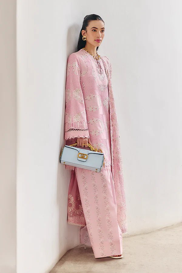 Model wearing a soft candy pink jacquard short shirt with sinuous embroidery and lace - detailed bell sleeves, paired with a wide - bottom floral print shalwar and an embroidered chiffon dupatta with organza borders. Available in the UK, brand Suffuse, Fall Casual Pret '24 collection.