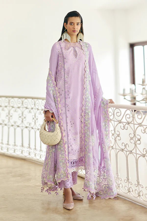 Model is wearing a lilac panelled jacquard shirt with floral embroidery, patchwork, and a crown - shaped organza neckline from Suffuse's Fall Casual Pret '24. Paired with straight cotton pants featuring lace details and cutwork finesse. The chiffon dupatta has organza borders and abstract prints. Available in the UK.