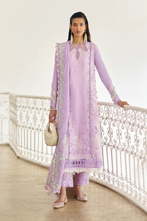 Model is wearing a lilac panelled jacquard shirt with floral embroidery, patchwork, and a crown - shaped organza neckline from Suffuse's Fall Casual Pret '24. Paired with straight cotton pants featuring lace details and cutwork finesse. The chiffon dupatta has organza borders and abstract prints. Available in the UK.