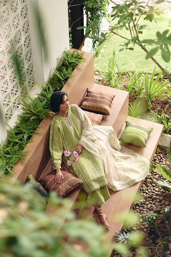 Model is wearing a parrot green jacquard kurta with organza applique, box sleeves, and intricate embroidery. Paired with matching culotte pants and a powder pink silk dupatta featuring contrasting embroidery. Available in the UK from Suffuse Fall Casual Pret '24.