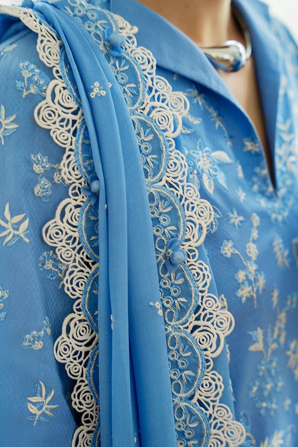 Denim blue pure cotton jacquard shirt with floral embroidery, scalloped bell sleeves, and lace detailing. Paired with embroidered off - white culotte pants and a chiffon dupatta featuring embroidered borders and tassels. Available in the UK, brand Suffuse, Casual Pret '24 collection.