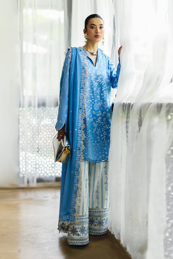 Denim blue pure cotton jacquard shirt with floral embroidery, scalloped bell sleeves, and lace detailing. Paired with embroidered off - white culotte pants and a chiffon dupatta featuring embroidered borders and tassels. Available in the UK, brand Suffuse, Casual Pret '24 collection.