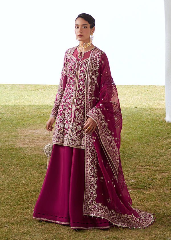 Model wearing a vibrant pink Ahlam dress from Suffuse's FREESHIA RTW '24 collection. Ideal for weddings, featuring intricate embroidery. Shop Pakistani clothes online in the UK.