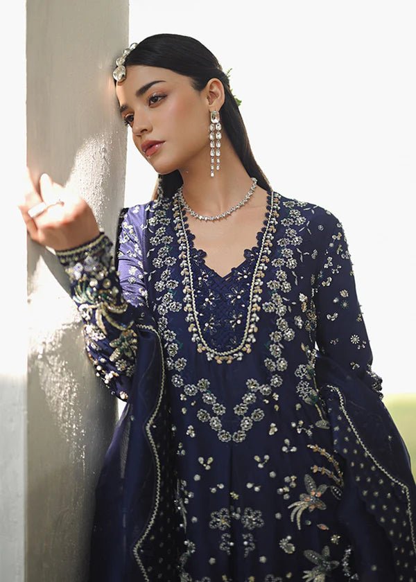 Model wearing a deep blue dress with intricate gold and green embroidery from the Suffuse FREESHIA RTW '24 Aroosh collection. Perfect for weddings. Pakistani clothes online in UK.