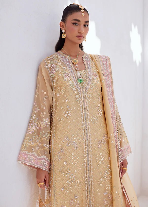 Model wearing SUHA dress in golden hues from Suffuse | FREESHIA RTW '24. Featuring intricate embroidery, this Pakistani wedding dress is available online in the UK.