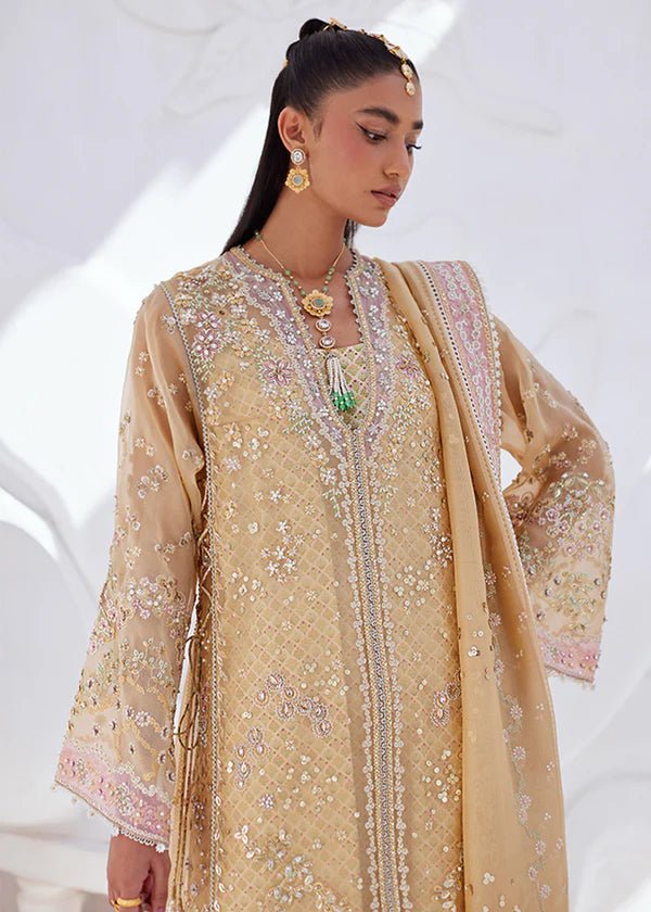 Model wearing SUHA dress in golden hues from Suffuse | FREESHIA RTW '24. Featuring intricate embroidery, this Pakistani wedding dress is available online in the UK.