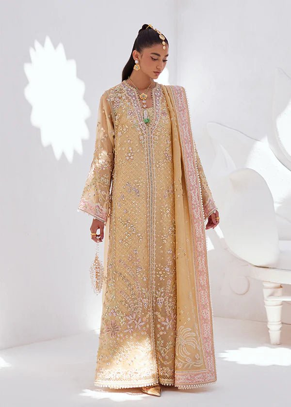 Model wearing SUHA dress in golden hues from Suffuse | FREESHIA RTW '24. Featuring intricate embroidery, this Pakistani wedding dress is available online in the UK.