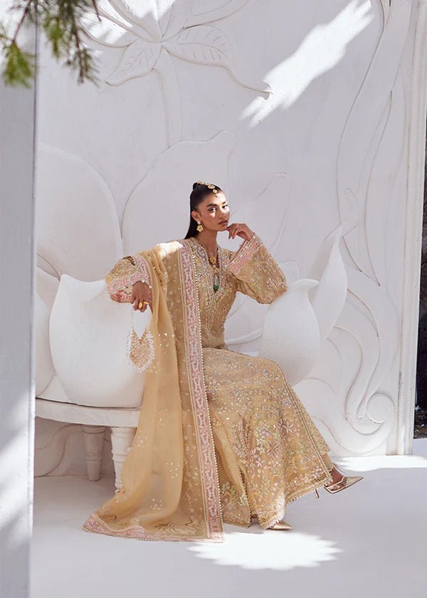 Model wearing SUHA dress in golden hues from Suffuse | FREESHIA RTW '24. Featuring intricate embroidery, this Pakistani wedding dress is available online in the UK.