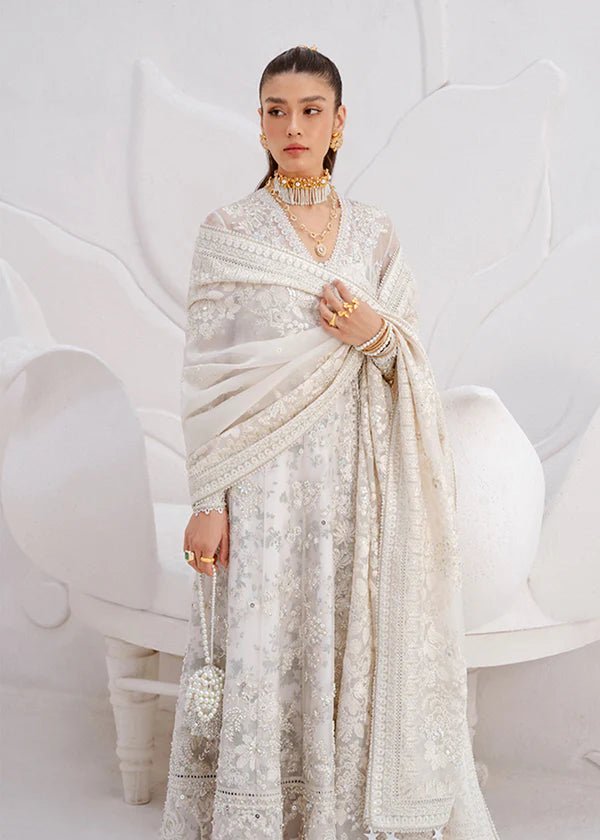 Model wearing an Model wearing a cream Yasna dress from Suffuse, showcasing intricate embroidery and embellishments. Ideal for wedding attire, available in the UK.