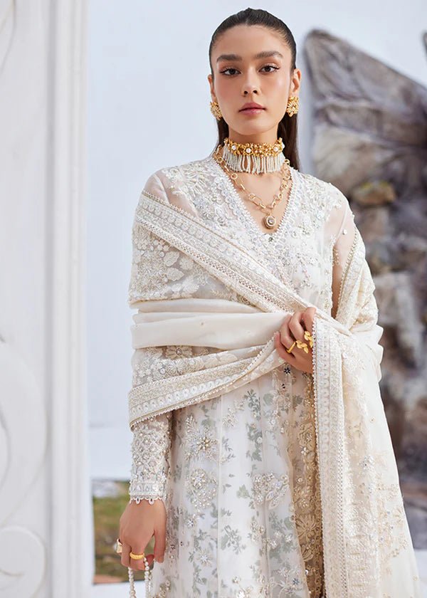 Model wearing an Model wearing a cream Yasna dress from Suffuse, showcasing intricate embroidery and embellishments. Ideal for wedding attire, available in the UK.