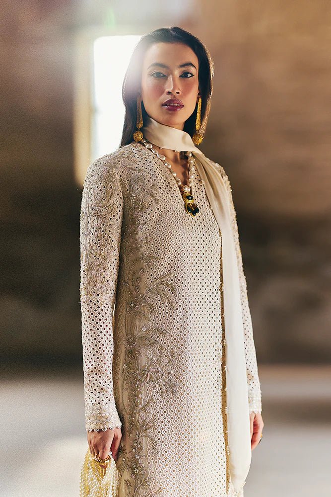 Model wearing Suffuse Silk Pret '24 Irana dress in ivory with intricate embellishments and delicate embroidery. Shop Pakistani bridal dresses online in the UK now.