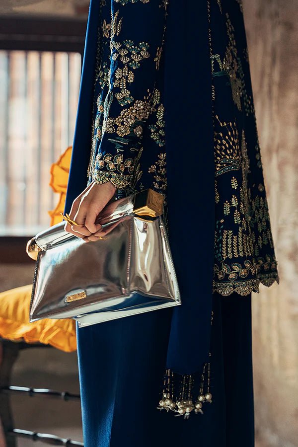 Model wearing dark blue Kira dress from Suffuse, adorned with golden embroidery, ideal for Eid and UK Pakistani fashion trends.