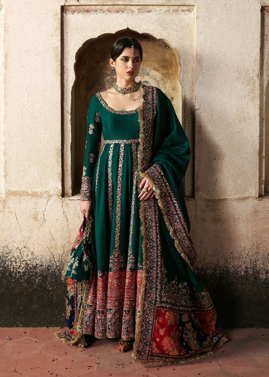 Model wearing Meherunissa by Hussain Rehar in deep bottle green with red accents – Pakistani luxury pret, shop Hussain Rehar in UK.