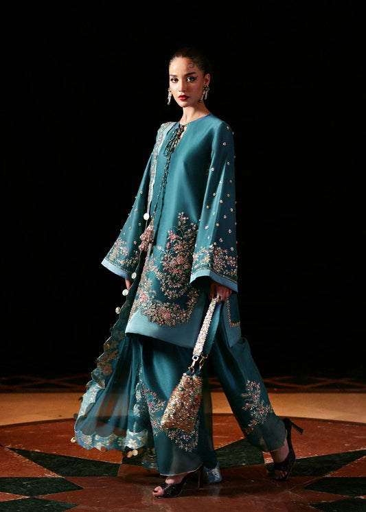 Model wearing teal blue Verta dress by Hussain Rehar, Pakistani luxury pret available online in UK for celebrations and events.
