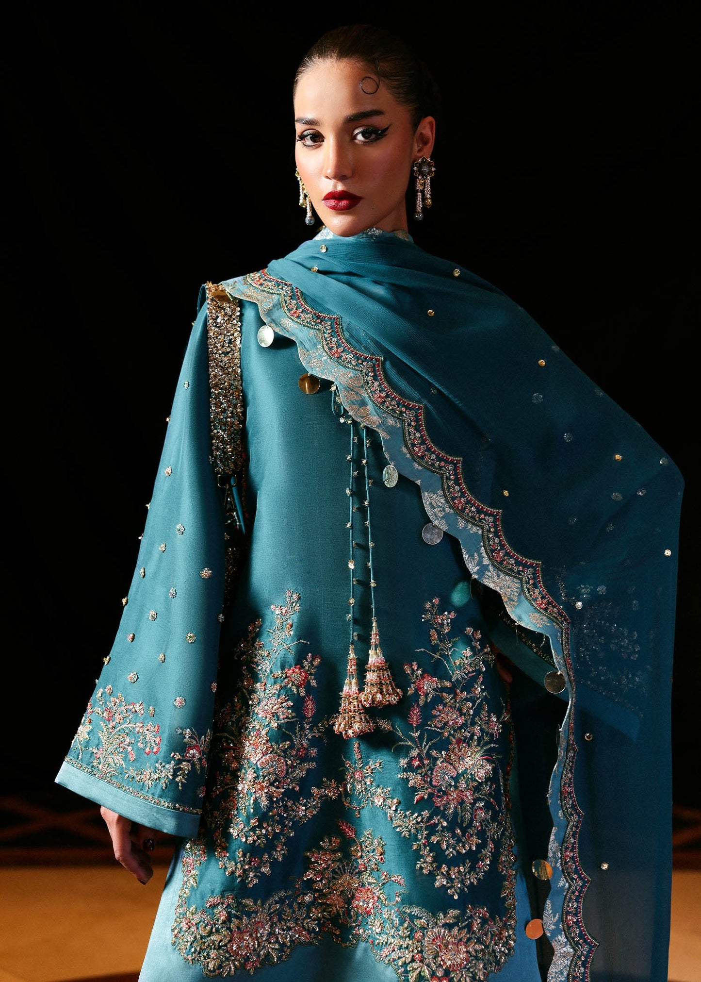 Model wearing teal blue Verta dress by Hussain Rehar, Pakistani luxury pret available online in UK for celebrations and events.
