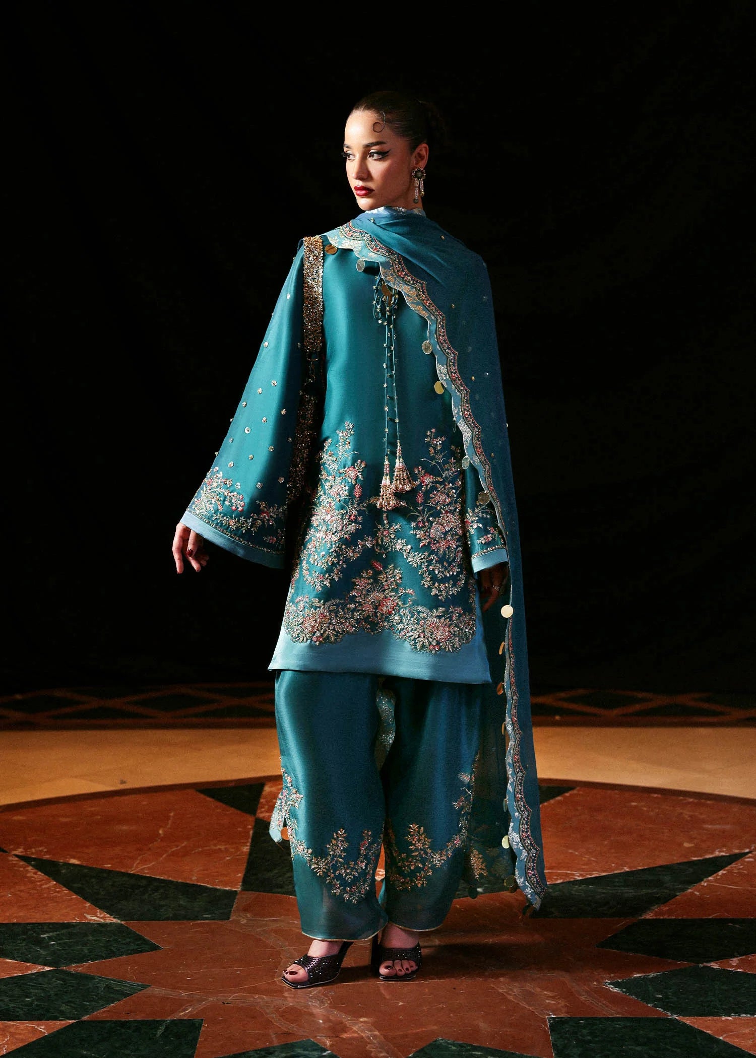 Model wearing teal blue Verta dress by Hussain Rehar, Pakistani luxury pret available online in UK for celebrations and events.
