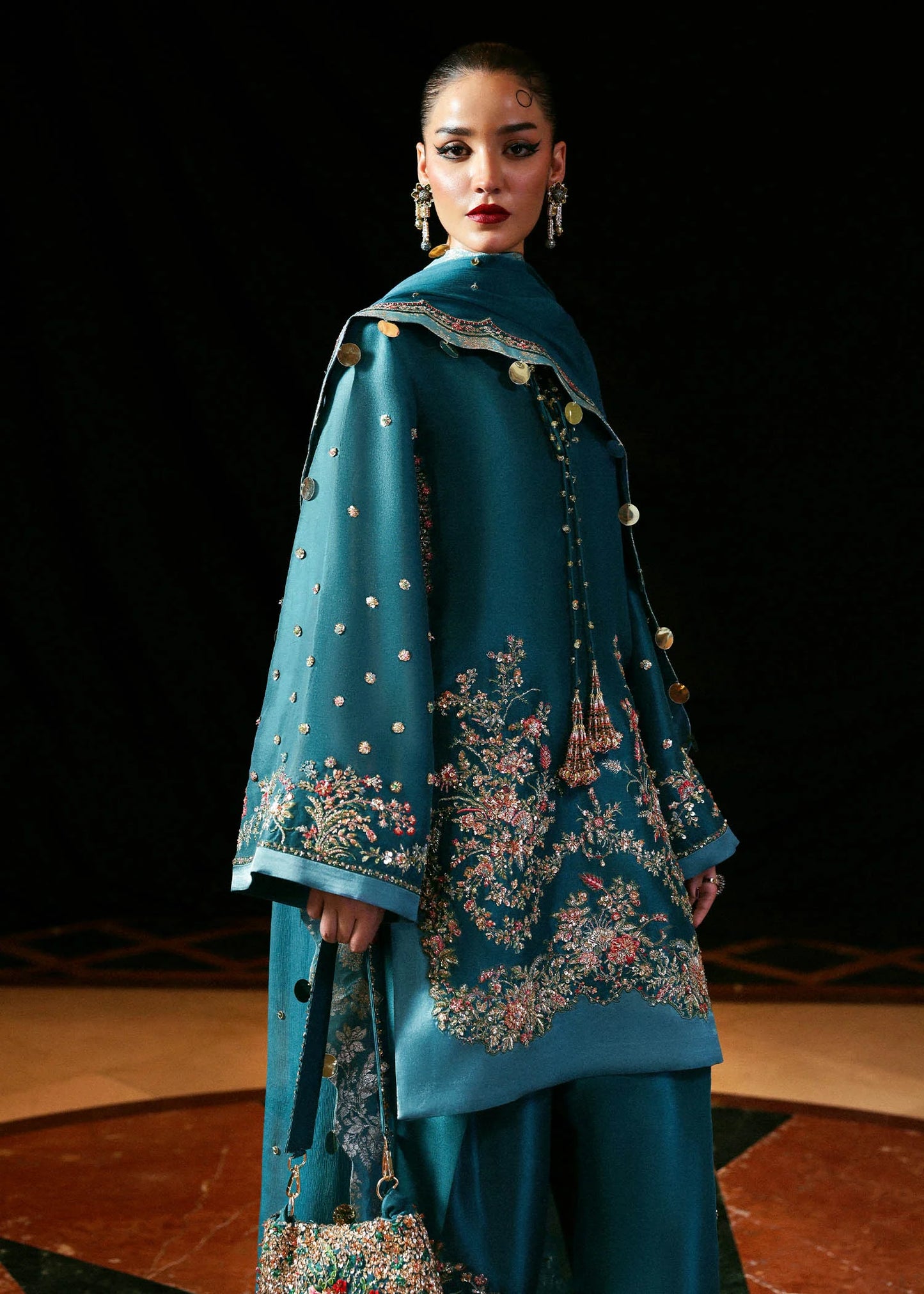 Model wearing teal blue Verta dress by Hussain Rehar, Pakistani luxury pret available online in UK for celebrations and events.
