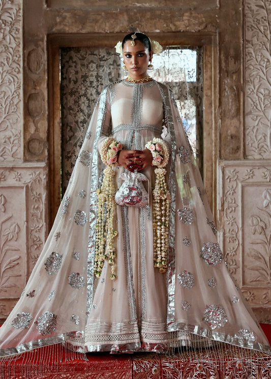 Model wearing Mina by Hussain Rehar in ivory with silver embellishments and cape – luxurious Pakistani luxury pret outfit in UK.
